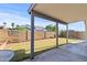 A backyard with a covered patio, grass lawn, block wall, and a low brick wall border at 3651 W Escuda Dr, Glendale, AZ 85308