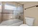Bathroom featuring a tub and shower combination with stone look tiles and a sliding glass door at 3651 W Escuda Dr, Glendale, AZ 85308
