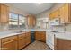 Kitchen with stainless steel sink, wooden cabinets, and white appliances at 3651 W Escuda Dr, Glendale, AZ 85308