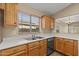 Kitchen with stainless steel sink, wooden cabinets, and a view out the window at 3651 W Escuda Dr, Glendale, AZ 85308