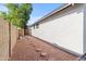 A side yard featuring a stone path, mature tree, and block wall for privacy at 3651 W Escuda Dr, Glendale, AZ 85308
