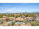 A stunning aerial view of homes with backyard pools, lush greenery, and distant mountain scenery at 4131 E Cascalote Dr, Cave Creek, AZ 85331