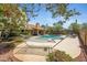 Backyard with pool, mature flowering trees, lush landscaping, covered patio, hammock, and lounge seating at 4131 E Cascalote Dr, Cave Creek, AZ 85331