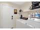 Functional laundry room with side-by-side washer and dryer, upper shelf storage, and utility sink at 4131 E Cascalote Dr, Cave Creek, AZ 85331