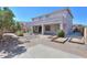 Rear view of the home with a covered patio, manicured yard, and horseshoe pits at 43561 W Snow Dr, Maricopa, AZ 85138