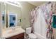 Well-lit bathroom showcasing vanity, toilet, and shower-tub combo with decorative curtain at 43561 W Snow Dr, Maricopa, AZ 85138