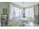 Charming dining area with a view of the yard, featuring white chairs and tile flooring at 43561 W Snow Dr, Maricopa, AZ 85138