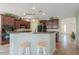 Modern kitchen boasts dark cabinetry, stainless steel appliances, and bar seating area at 43561 W Snow Dr, Maricopa, AZ 85138