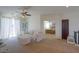A comfortable living room with a floral-print sofa, ceiling fan, and view into the adjacent bedroom at 43561 W Snow Dr, Maricopa, AZ 85138