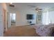 Bright living room featuring a ceiling fan, TV, and sliding glass doors leading to outdoor space at 43561 W Snow Dr, Maricopa, AZ 85138