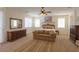Spacious carpeted primary bedroom with a couch and a bed with a decorative headboard at 43561 W Snow Dr, Maricopa, AZ 85138