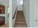 Carpeted staircase with wooden handrail leading to upper level of the home at 43561 W Snow Dr, Maricopa, AZ 85138