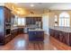 A kitchen features rich wood cabinets, granite countertops, stainless steel appliances, and a center island with a glass cooktop at 4410 E Robin Ln, Phoenix, AZ 85050