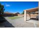 Well-maintained backyard featuring a rectangular lawn, gravel landscaping, and a covered patio at 44865 W Woody Rd, Maricopa, AZ 85139