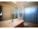Bathroom with a tiled shower curtain, a mirror, and a wood cabinet at 44865 W Woody Rd, Maricopa, AZ 85139