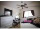 Cozy bedroom with a ceiling fan, TV, white furniture, and window with curtains at 44865 W Woody Rd, Maricopa, AZ 85139