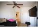 Bedroom featuring a ceiling fan, TV, and a view of the staircase at 44865 W Woody Rd, Maricopa, AZ 85139