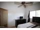 Bedroom with ceiling fan, dark furniture, neutral colored walls at 44865 W Woody Rd, Maricopa, AZ 85139
