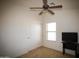 Bedroom featuring a ceiling fan and sliding door closet with a desk and TV at 44865 W Woody Rd, Maricopa, AZ 85139