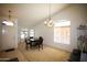 Bright dining room with vaulted ceilings, large windows, and a modern chandelier at 44865 W Woody Rd, Maricopa, AZ 85139