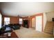 Spacious living room featuring a comfortable leather sofa, ceiling fan, and staircase to upper level at 44865 W Woody Rd, Maricopa, AZ 85139