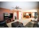 Open-concept living room featuring a ceiling fan, and seamless flow into the dining area and kitchen at 44865 W Woody Rd, Maricopa, AZ 85139