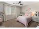 Bedroom features a light pink bed, carpet and white plantation shutters at 5434 E Barwick Dr, Cave Creek, AZ 85331