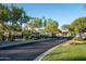 Community entrance gate with stone wall, lush landscaping, and paved road at 5434 E Barwick Dr, Cave Creek, AZ 85331