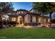 Elegant home featuring beautiful stone accents, arched entryway, landscaped yard, and an American flag at 5434 E Barwick Dr, Cave Creek, AZ 85331