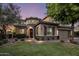 Elegant home with stone accents, arched entryway, and landscaped front yard at twilight at 5434 E Barwick Dr, Cave Creek, AZ 85331