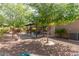 Backyard featuring a covered patio and mature trees providing shade at 5707 N Kristi Ln, Litchfield Park, AZ 85340