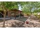 Serene backyard featuring a covered patio and mature trees at 5707 N Kristi Ln, Litchfield Park, AZ 85340