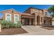 Charming two-story home featuring a terracotta tile roof, arched entry, and low-maintenance desert landscaping at 5707 N Kristi Ln, Litchfield Park, AZ 85340