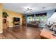 Spacious living room with wood laminate floors, ceiling fan, and plenty of natural light at 5707 N Kristi Ln, Litchfield Park, AZ 85340