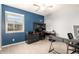 A home office with blue and gray walls, carpet, and a window with natural light at 5707 N Kristi Ln, Litchfield Park, AZ 85340