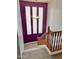 View of the staircase showing the natural light from the large window and a purple accent wall at 5707 N Kristi Ln, Litchfield Park, AZ 85340