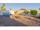 Gravel-covered backyard with a Connect Four game, cornhole boards, fire pit, and palm trees at 603 W Keats Ave, Mesa, AZ 85210
