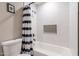 Bright bathroom with white tiled walls and a modern showerhead above a tub with shower curtain at 603 W Keats Ave, Mesa, AZ 85210