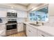 Updated kitchen with white cabinets, stainless steel appliances, quartz countertops, stylish subway tile backsplash, and a large sink at 603 W Keats Ave, Mesa, AZ 85210