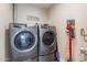 Well-equipped laundry room featuring gray washer and dryer, plus convenient cleaning supplies storage at 603 W Keats Ave, Mesa, AZ 85210