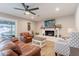 Bright living room with leather seating, a white brick fireplace with wood mantle, and a ceiling fan at 603 W Keats Ave, Mesa, AZ 85210