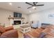 Cozy living room with brown leather seating, a white brick fireplace with wood mantle, and wood-look tile floors at 603 W Keats Ave, Mesa, AZ 85210