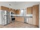 Modern kitchen features stainless steel appliances, wood cabinets, gray countertops, and tile floors at 610 E Roosevelt St # 145, Phoenix, AZ 85004