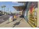 Exterior street view featuring a bus stop, colorful art, and palm trees at 610 E Roosevelt St # 145, Phoenix, AZ 85004