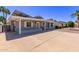 View of the home's side featuring solar panels, white trim, desert landscaping, and a spacious driveway at 619 S Essex Ln, Mesa, AZ 85208