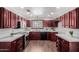 Well-lit kitchen with stainless steel appliances, dark wood cabinets, and tile flooring at 619 S Essex Ln, Mesa, AZ 85208
