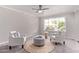 Bright living room featuring two white armchairs, an ottoman and a large window at 619 S Essex Ln, Mesa, AZ 85208