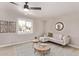 Bright living room with neutral decor, ceiling fan, and stylish coffee tables at 619 S Essex Ln, Mesa, AZ 85208