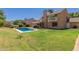 Spacious backyard featuring a pool, patio area with outdoor kitchen, and a well-maintained lawn at 6446 E Beverly Ln, Scottsdale, AZ 85254
