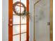 Detailed view of a decorative wreath on a wooden door with a frosted glass panel, next to a glass shower at 6446 E Beverly Ln, Scottsdale, AZ 85254
